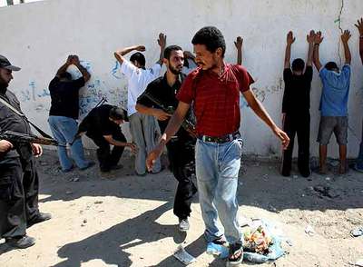 Miembros de las fuerzas policiales de Hamás arrestan a sospechosos durante una redada en busca de armas el sábado en Gaza.