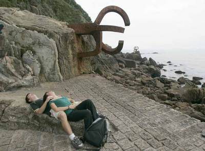 Una pareja junto a 'El Peine de los Vientos', espacio diseñado por Peña Ganchegui con esculturas de Eduardo Chillida, en San Sebastián.