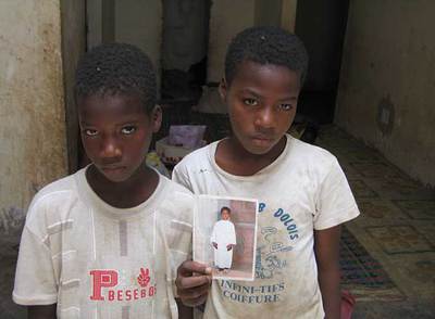 Dos hermanos de la familia Doua, repatriados de los Emiratos Árabes Unidos, muestran en Nuakchot una foto de un tercer hermano que falleció durante una carrera de camellos en Dubai. Cientos de niños mauritanos trabajaron en Dubai como jinetes de camellos.