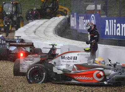 Cuatro coches, entre ellos el de Hamilton, en primer plano, esperan a la grúa tras salirse de pista.