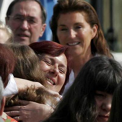 Cécilia Sarkozy sonríe mientras dos enfermeras excarceladas abrazan en Sofía a sus familiares.