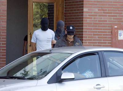 Joseba Mikel Otxoa (a la izquierda), detenido ayer en Vitoria, sale de su domicilio custodiado por dos  ertzainas .
