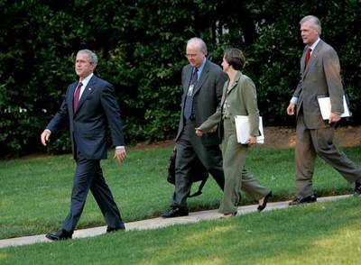 George W.Bush, seguido de sus consejeros Karl Rove, Candi Wolff y Tony Snow, en los jardines de la Casa Blanca.