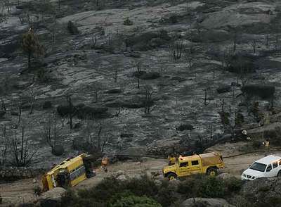 Un  hummer  (todoterreno de grandes dimensiones) volcado en mitad de la zona arrasada por el fuego.