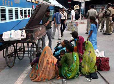 Un grupo de mujeres y niños aguarda un tren en la estación de Nueva Delhi.
