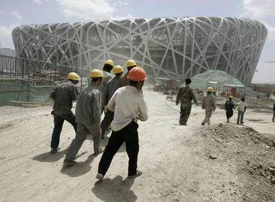Un grupo de trabajadores junto al Estadio Nacional Olímpico, el  Bird's Nest , que se está construyendo en Pekín.