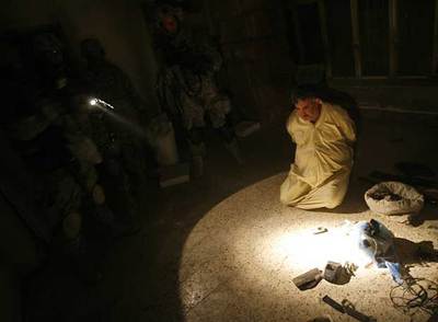 Soldados estadounidenses vigilan a un iraquí que tenía material explosivo en su casa de Bagdad.