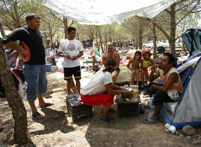 Trabajadores rumanos acampados en el pinar de La Herrera (Albacete), durante la hora de la comida de ayer.