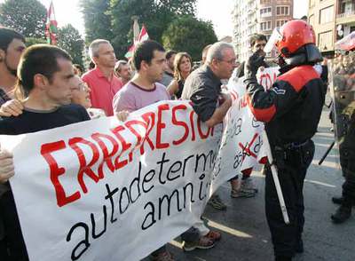El líder de Askatasuna, Juan Mari Olano, habla con un  ertzaina  ante la mirada de Joseba Permach.