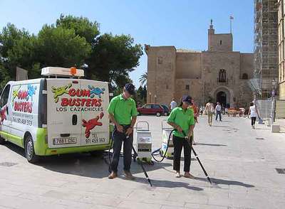 La brigada  cazachicles,  en Palma de Mallorca. Abajo, una operaria en pleno proceso de limpieza.