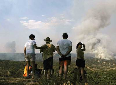 Un grupo de personas observa el incendio del campo de tiro de Cerro Muriano, el pasado 29 de julio.