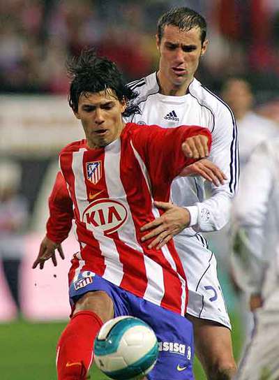 Agüero controla el balón ante Helguera.