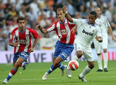 Robinho se lleva el balón ante Pernía y Simao.