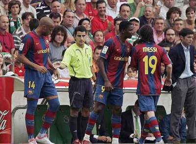 Henry espera para entrar en el terreno de juego mientras Eto'o habla con el sustituido Messi.