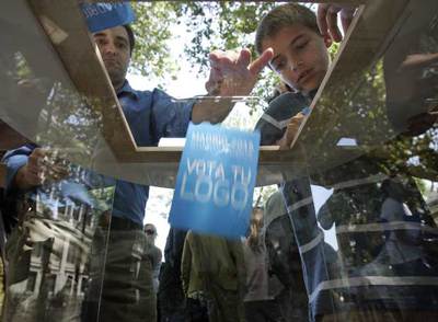 Varios ciudadanos votando ayer su logo preferido para la candidatura olímpica de Madrid.
