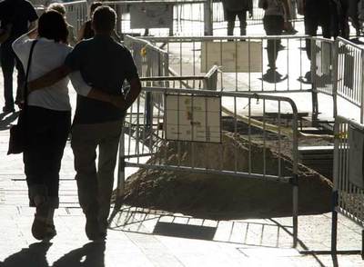 Una pareja pasea junto a varias zanjas en la calle de Alcalá.