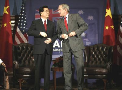George W. Bush y Hu Jintao se abrochan las chaquetas al término de una reunión ayer en Sidney.