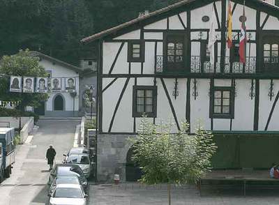 El Ayuntamiento de Lizartza, con las banderas española y vasca. A la izquierda, fotografías de presos etarras.