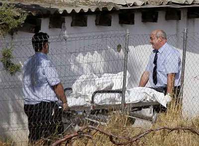 Personal de la funeraria recoge el cadáver de la mujer de 45 años asesinada ayer por su pareja.