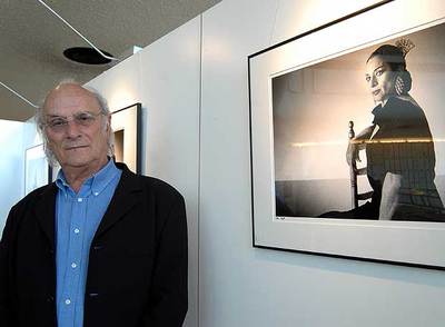 Carlos Saura, en su exposición en Ginebra, junto a una imagen de Lola Flores.