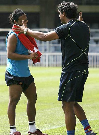 Rijkaard bromea con Ronaldinho durante la pretemporada en China.