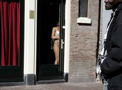 Una prostituta se exhibe ante los transeúntes en un burdel del  distrito rojo  de Ámsterdam.