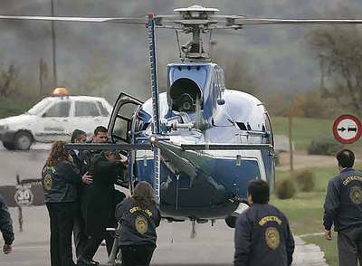 Agentes de la policía chilena ayudan a Alberto Fujimori a subir al helicóptero que lo condujo ayer al aeropuerto de Santiago.