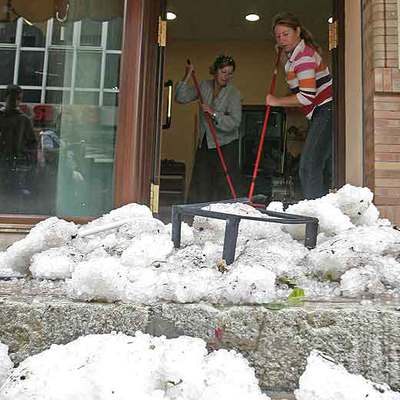 Dos mujeres retiraban ayer el granizo en una tienda de ropa de la calle de La Mina.