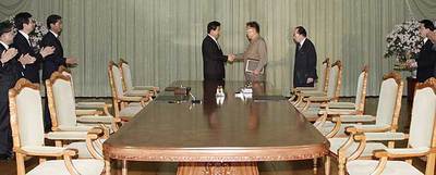 El presidente surcoreano, Roh Moo-hyun (izquierda), estrecha la mano del mandatario norcoreano, Kim Jong-il, tras el compromiso alcanzado ayer en Pyongyang.