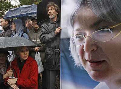 Un grupo de personas permanece junto a un retrato de Anna Politkóvskaya durante una marcha ayer en Moscú.