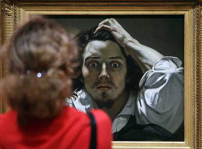 Una mujer contempla el autorretrato de Courbet, titulado  Le désésperé,  expuesto en el Grand Palais de París.