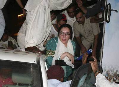 La ex primera ministra paquistaní Benazir Bhutto sale del vehículo en el que se encontraba, tras el atentado en Karachi.