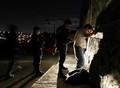Un policía cachea a un sospechoso en busca de drogas o  armas en una operación en Álvaro Obregón, en Ciudad de México.