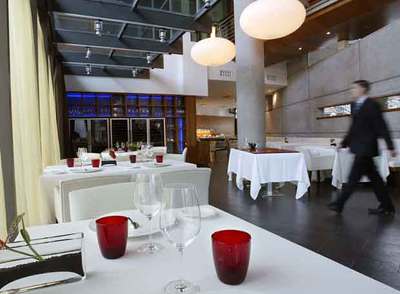 Comedor del restaurante Syrah. Abajo, sardinas a la brasa con  trinxat  de la Cerdanya y aro de pies de cerdo.