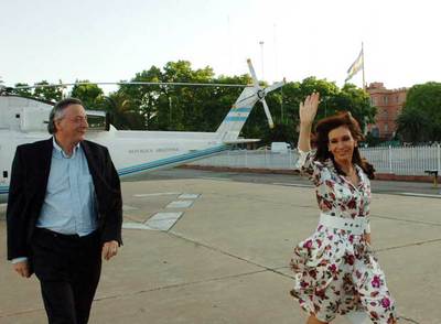 Cristina Fernández de Kirchner saluda a su llegada al helipuerto de la Casa Rosada, en Buenos Aires, acompañada de su marido, Néstor Kirchner.