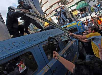 Un grupo de estudiantes se enfrenta a la  policía antidisturbios durante la manifestación, ayer en Caracas.