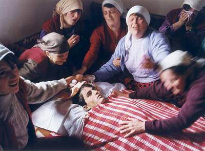 Mujeres albanokosovares lloran en Dragobil ante el cadáver de Ali Murat Pacarizi, soldado del Ejército de Liberación de Kosovo,  en una foto ganadora del Premio Ortega y Gasset de 1999, expuesta en  Latidos de un mundo convulso. 