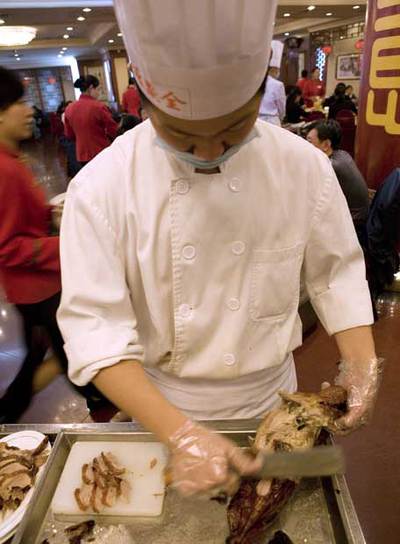 Un cocinero despieza un pato en un restaurante Quanjude.