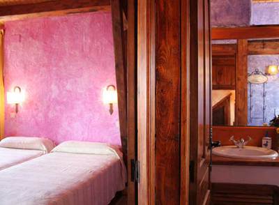 Habitación y baño de una de las cinco viviendas creadas tras la rehabilitación de una  granja: Casas Cavas, en Olmedo (Valladolid).