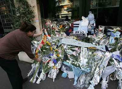 Una mujer coloca un ramo de flores en la tienda donde Sandri trabajaba con su padre en Roma.