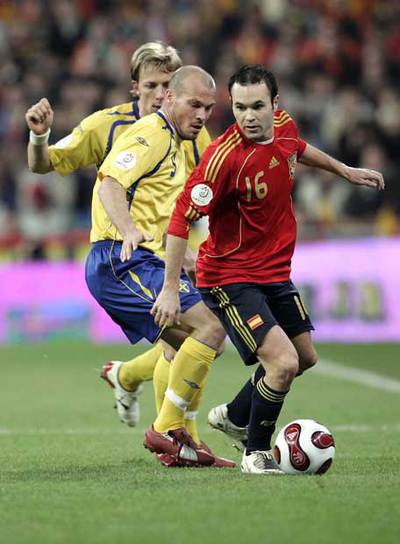 Iniesta conduce el balón presionado por Ljungberg y Edman.