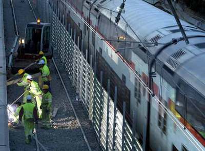 Un tren de Cercanías pasa al lado de las obras del AVE en Bellvitge.