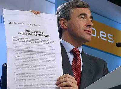 Ángel Acebes muestra un comunicado de Renfe sobre el AVE durante la rueda de prensa de ayer.