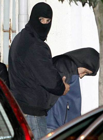 Un agente traslada a uno de los detenidos ayer en Burlada.