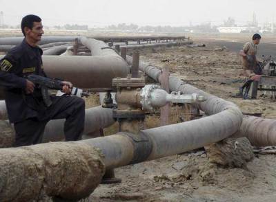 Un guardia de seguridad y un obrero, en el oleoducto de una refinería en el pueblo de Umm Quasar, al sur de Irak, ayer.