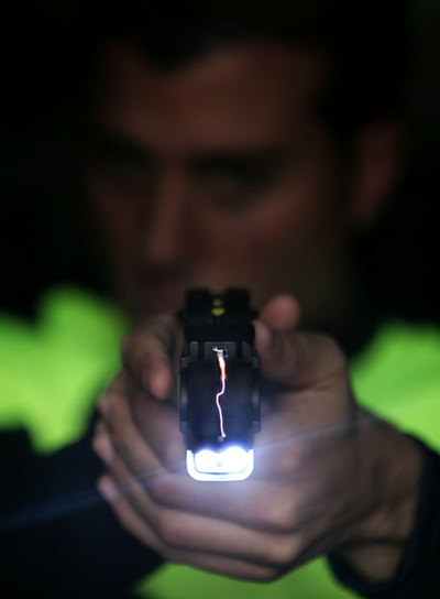 Un agente de la Policía Local de Moraleja de Enmedio (Madrid) empuña una pistola Taser.
