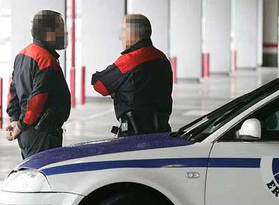 Los agentes de la Ertzaintza Koldo y Eduardo charlan junto a su coche patrulla, en un aparcamiento público cerca de la capital vizcaína.