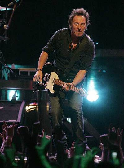 Bruce Springsteen toca la guitarra durante su actuación.