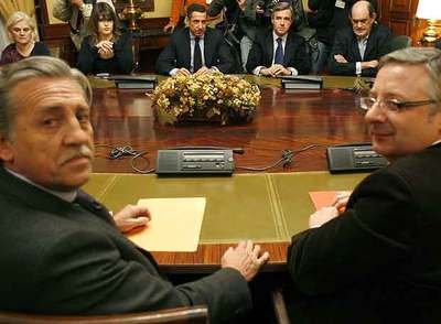López Garrido y Blanco (PSOE), en primer término, durante la reunión en el Congreso. Al otro lado de la mesa, Zaplana, Acebes y Astarloa (PP), entre otros parlamentarios.