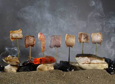 Plato  Calima,  una playa de pescados y mariscos dispuestos como los tradicionales espetos malagueños.